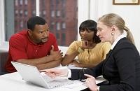 Three people around a laptop