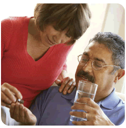 Mujer y hombre con un vaso de agua y tomando pastillas.